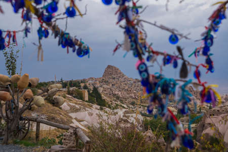 Evil eye in tree behind Uchisar Castle in Cappadocia, Uchisar, Turkey. Tree hanging Nazar amulets, a special eye-shaped objects that protect against the evil eyeの写真素材