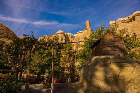 Pigeon valley in Cappadocia, Goreme, Turkey. Beautiful landscape with cliffs and a cafe on the background of blue sky in Sunny weather.の写真素材