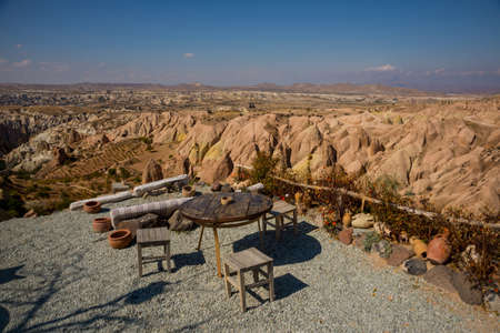 Tables and chairs for tourists on the observation deck. Travel to Turkey - observation deck on the Aktepe Hill and valley in Nevsehir province in Cappadocia, Anatolia.の写真素材