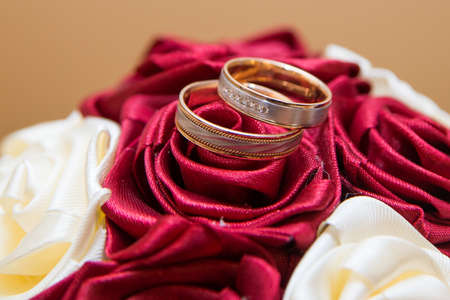 Wedding rings of the bride and groom on a Beautiful wedding bouquet of red and white roses. Wedding...