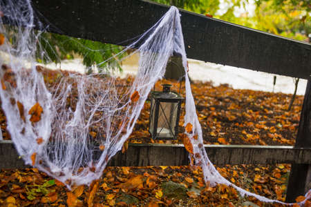White spider Web and lantern on wooden bridge in autumn forest on Halloween holiday. Denmark, Europeの写真素材