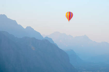 VANG VIENG, LAOS: beautiful landscape with a striped balloon flying over the land and mountains of Laos. Popular entertainment for tourists.の写真素材