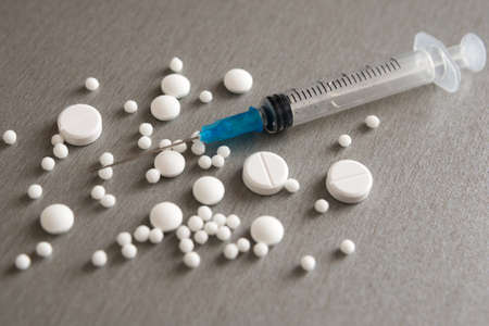 The medical syringe, thermometer and tablets are on the table. Tools needed for the virus.
