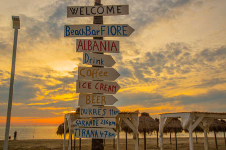 DURRES, ALBANIA: Inscriptions in the form of arrows, signs on the beach at sunset in Durres.の写真素材
