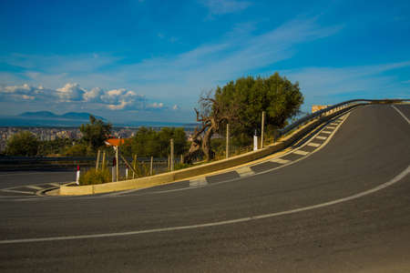 VLORA, ALBANIA: Paved road goes serpentine, view of the city of Vlora and Sazani Island.の写真素材