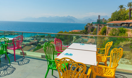 ANTALYA, TURKEY: Colorful chairs in the restaurant with a view of the sea and the old town. Beautiful top view of the cafe, the Mediterranean Sea and the mountains in Antalya, Turkey.のeditorial素材