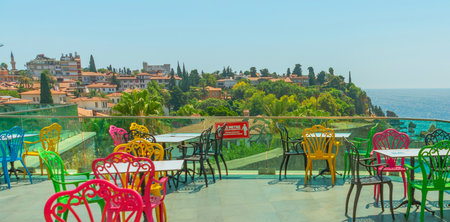 ANTALYA, TURKEY: Colorful chairs in the restaurant with a view of the sea and the old town. Beautiful top view of the cafe, the Mediterranean Sea and the mountains in Antalya, Turkey.のeditorial素材