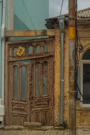 KUTAISI, GEORGIA: An old wooden door on the street. Traditional Georgian houses on the street in the old district of Kutaisi.の写真素材