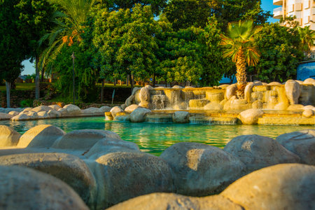 ANTALYA, TURKEY: Landscape with a view of a beautiful park with a fountain and a pond in the center of the Turkish city of Antalya on a sunny summer day.のeditorial素材