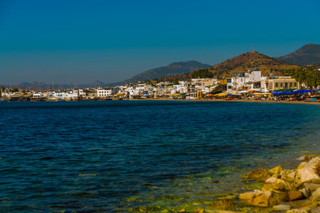 BODRUM, MUGLA, TURKEY: View of the white houses and the beach and the mountains in the city of Bodrum on a sunny day.のeditorial素材