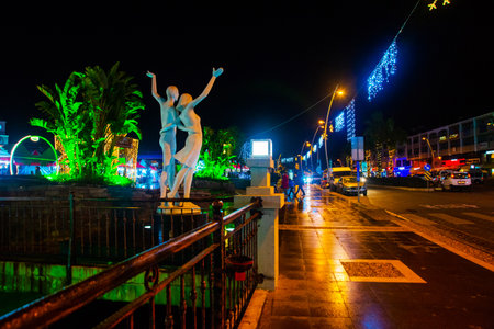 MARMARIS, MUGLA, TURKEY: Sculpture of a man and a woman by the canal in the center of Marmaris at night.のeditorial素材