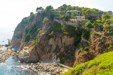 TOSSA DE MAR, CATALONIA, SPAIN: People enjoy the sun as they lay on the beach at Tossa de Mar on a...