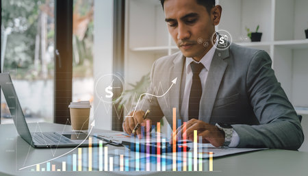 Businessman using laptop with digital graph chart on screen. Financial and trading concept.の素材