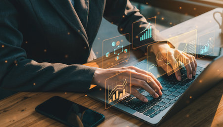 Business woman working with laptop and mobile phone on wooden table in coffee shop with double exposure of business graph icon.の素材