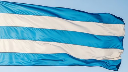 National flag of the Republic of Uruguay waving in the wind against the blue skyの素材