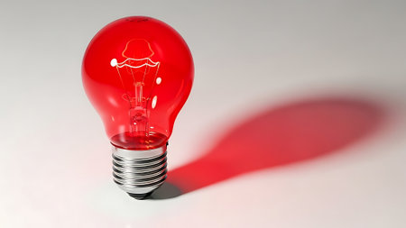 Red light bulb with shadow on white background. 3D rendering.の素材