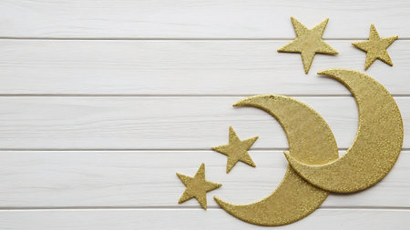 Ramadhan islamic themed background with gold glitter moon and stars on white wooden plank for decorationの素材