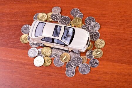 Model car on a placer of coins on the tableの写真素材