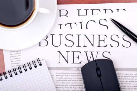 Several newspapers and cup of coffee on tableの写真素材