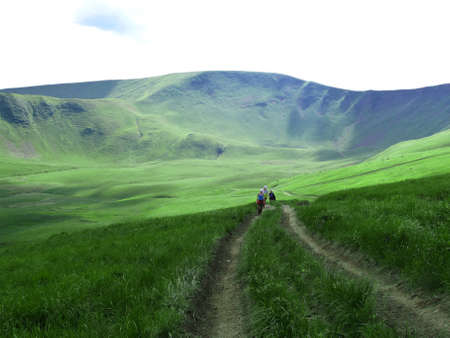 Tourists walk along the road from the foot of the hill