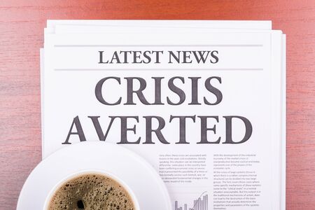 The newspaper LATEST NEWSwith the headline CRISIS AVERTED  and coffeeの写真素材