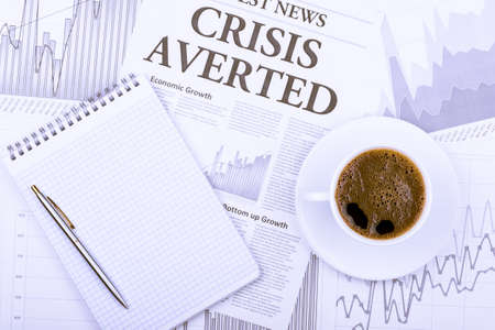 A cup of coffee and newspaper on the graphs view topの写真素材