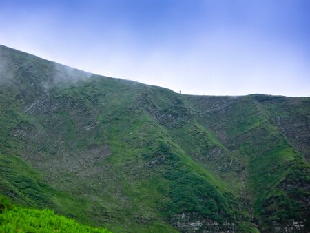 Lone traveler is on the ridge of the mountain