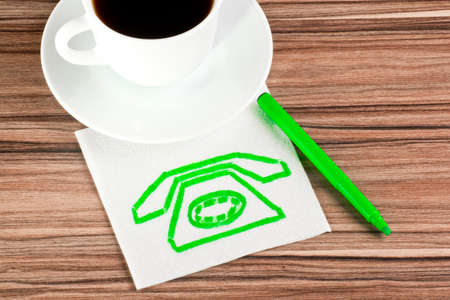 Old phone on a napkin and cup of coffeeの写真素材