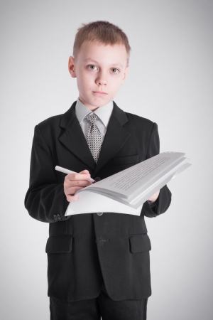 Boy in a business suit writingの写真素材