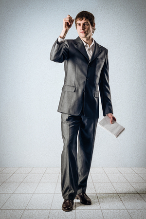 Business man writing on a transparent wallの写真素材