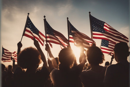 Group of people holding american flags in front of sunset sky.の写真素材