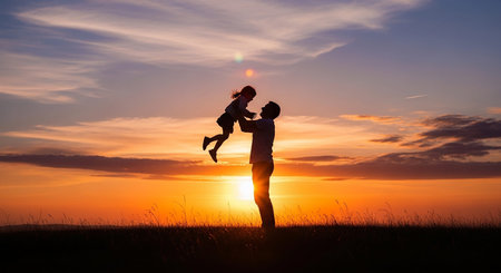 Silhouette of father and little daughter on sunset sky background.の素材