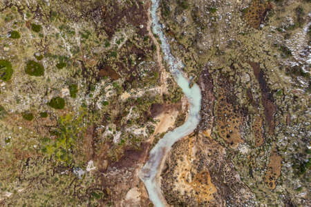 Aerial view of a river with blue water that crosses the mountains. The view allows you to observe...