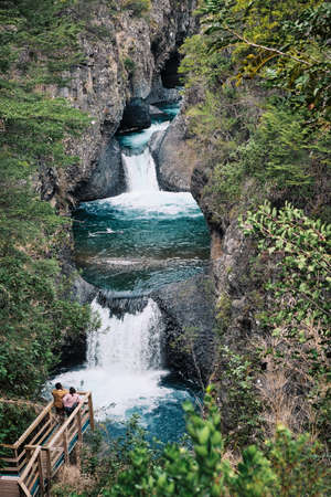 Tourists watching the waterfalls in the Radal Siete Tazas Natural Park. Chile
