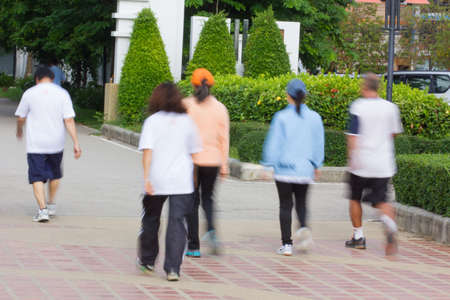 Blurred image of people walking in a park, outdoor exerciseの写真素材