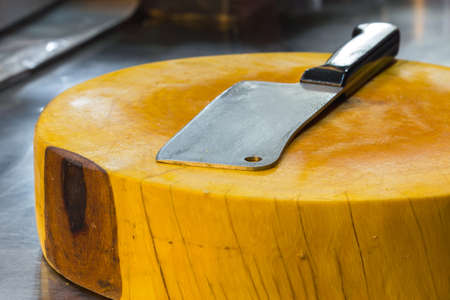 cleaver on yellow big chopping block in sidewalk restaurant in thailandの写真素材