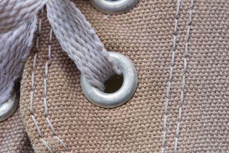 eyelet tab of canvas shoe, with shoelace, close-upの写真素材