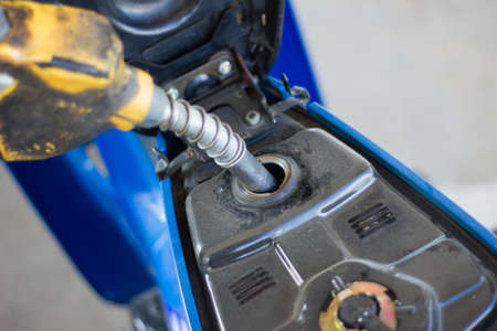 Refueling a motorcycle at a gas station in thailandの写真素材