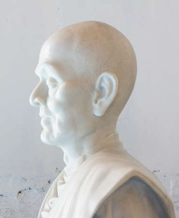 statue of buddha in temple of Thailand, white stone, on white wall as backgroundの写真素材