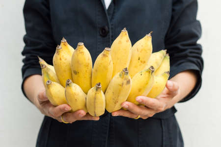 Closeup on young woman holding cluster of bananasの写真素材