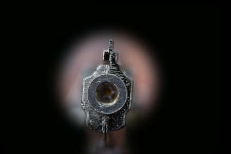 gun in keyhole isolated on black backgroundの写真素材