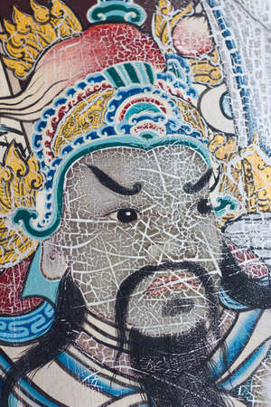 Painting face of ancient Asian warrior on a door in Wat Pho is the important temple in Bangkok,...