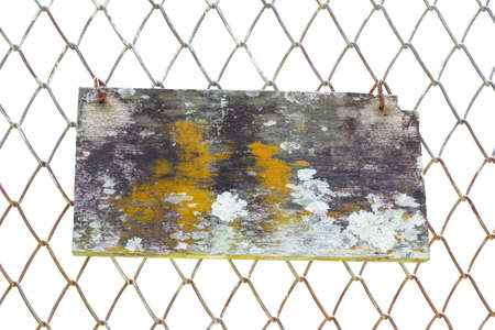 Old wood with moss and fungus hanging on wire fence isolated on whiteの写真素材
