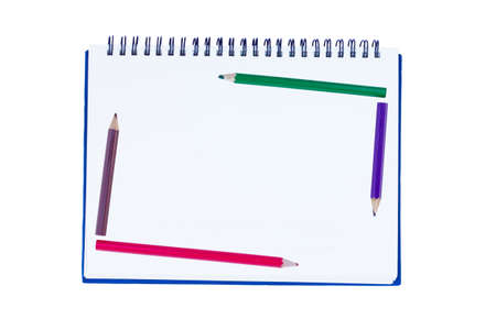blank notebook with metal spiral and five crayons in the border of the book isolated on white...