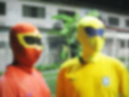 defocused of two men with masks in red and yellow cloths.の写真素材