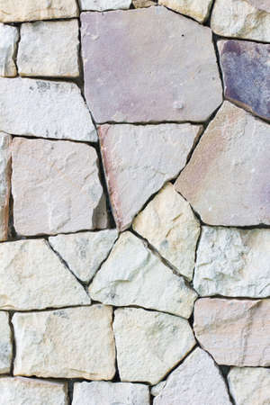 Multi-colored and multi-sized, pale rocks wall grunge texture background.