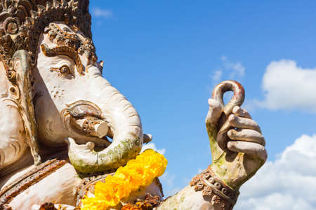 close-up statute of Ganesha outdoor against blue sky and white clouds.の写真素材
