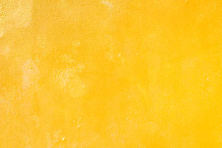 Yellow grunge cement wall, textured backgroundの写真素材