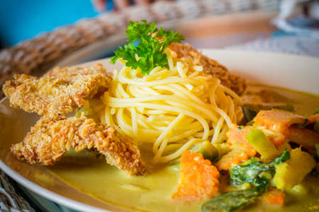 close-up of spaghetti green curry with fried pork on tabl, thai styleの写真素材
