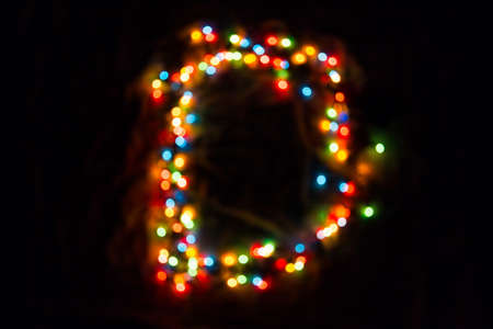colorful letter D made of blurred circular bokeh on black backgroundの写真素材